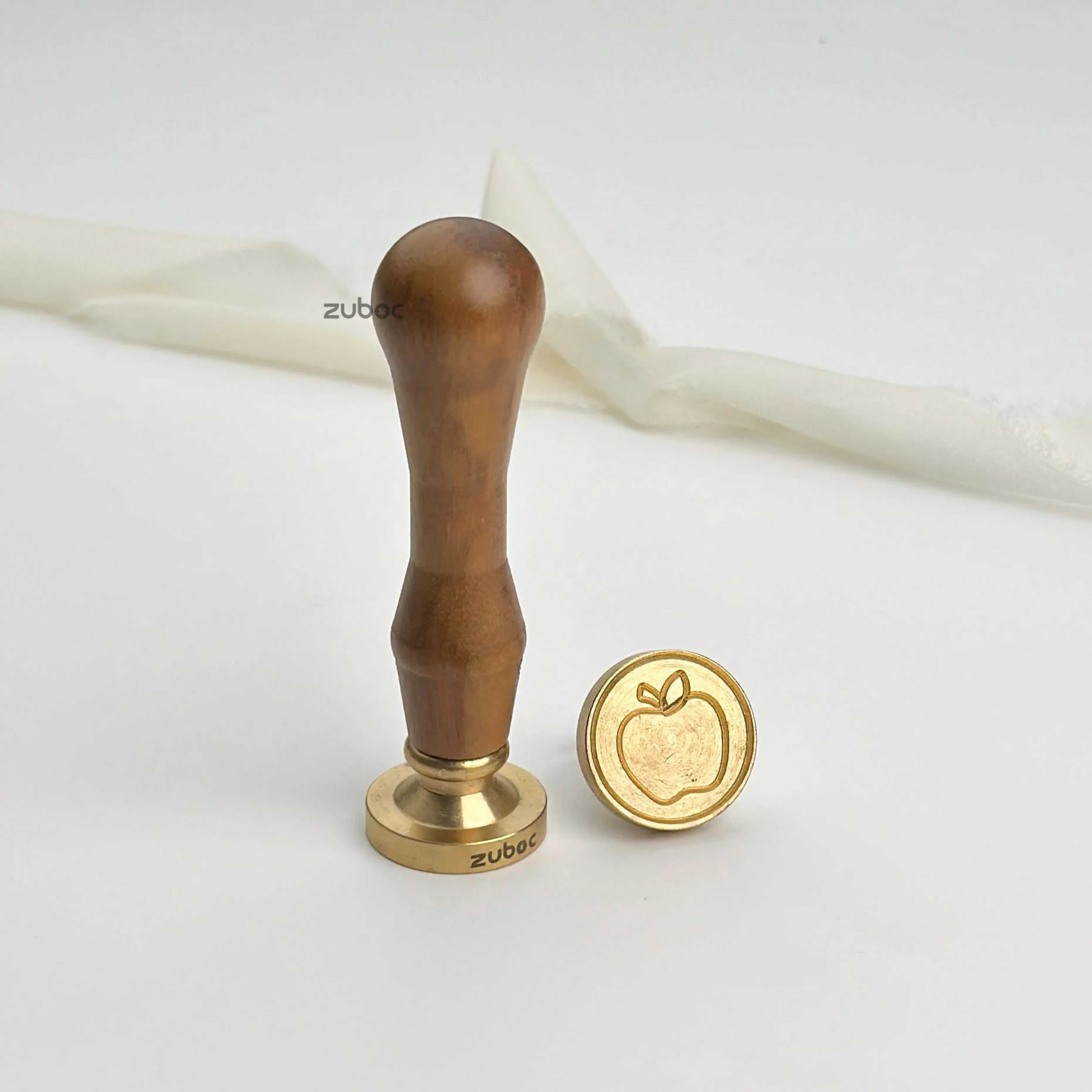 Red wax stamp with wooden handle for elegant gift wrapping and luxury invitations