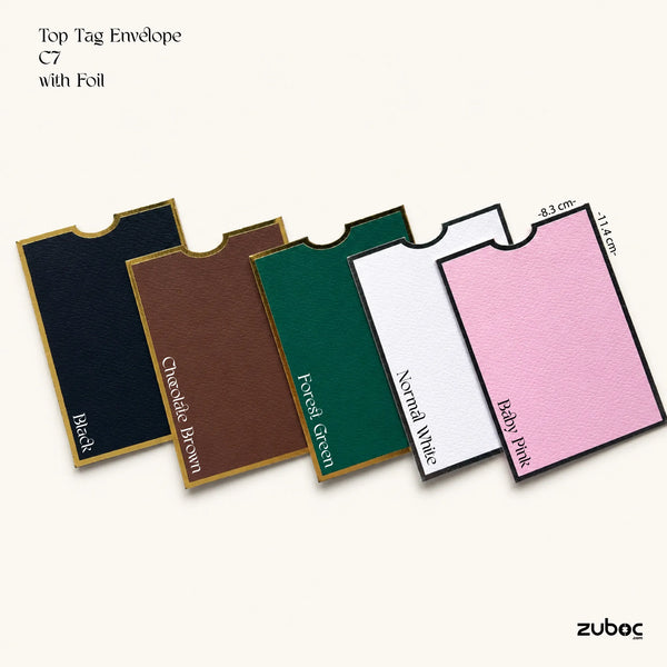 Five top tag envelopes in different colors are arranged diagonally on a light cream background. The available colors are labelled on the card Black, Chocolate Brown, Forest Green, Normal White, and Baby Pink.