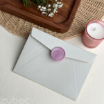 Lightest grey wedding invitation envelope with lily wax seal