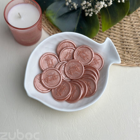 Be Our Guest' wax seal in rose gold color on elegant envelopes