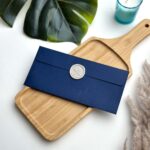 Plain navy blue money envelope with light grey spoon and fork wax seal